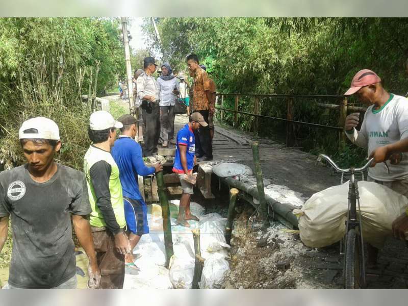 Bersama Warga, Bhabinkamtibmas Desa Klepek Sukosewu Perbaiki Tanggul Jembatan