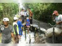Bersama Warga, Bhabinkamtibmas Desa Klepek Sukosewu Perbaiki Tanggul Jembatan