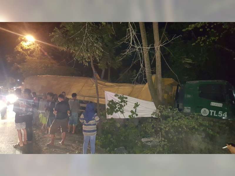 Hindari Motor, Truk Trailer Muat Semen Tabrak Pagar Gudang