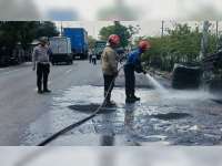 Usai Kecelakaan, Dinas Damkar Bojonegoro Bersihkan Minyak Goreng Bekas yang Tumpah di Jalan